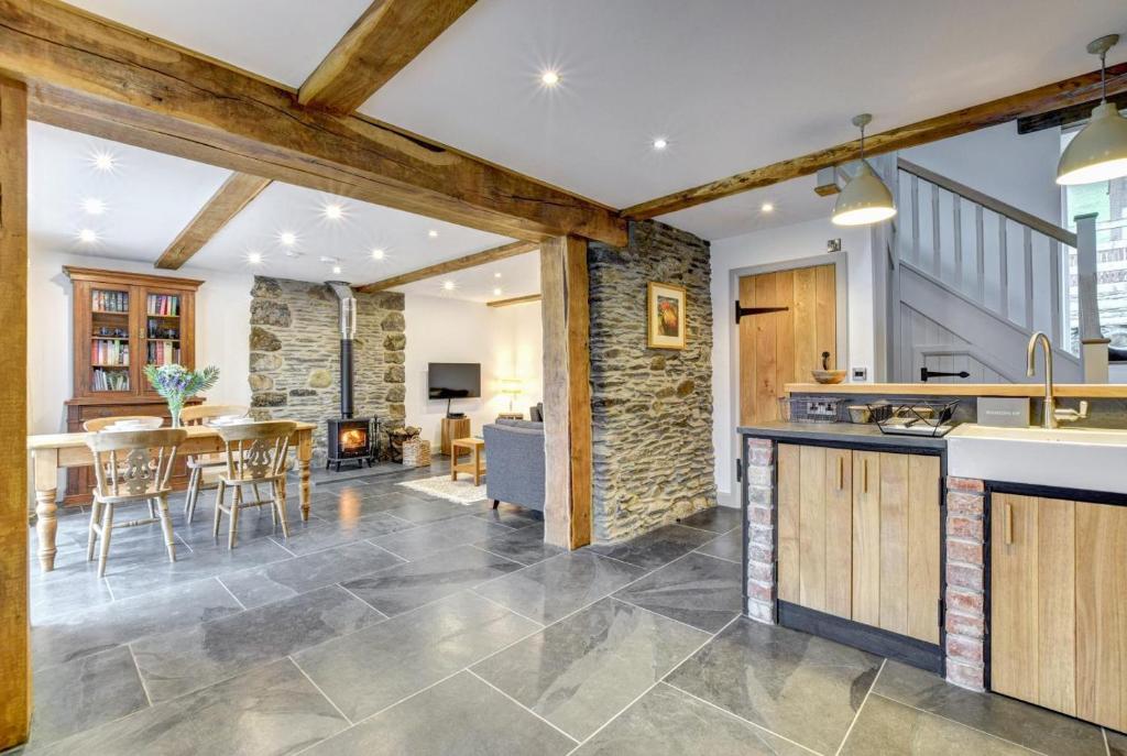 an open kitchen and living room with a stone wall at 2 Bed in Machynlleth oc-bow39 in Darowen