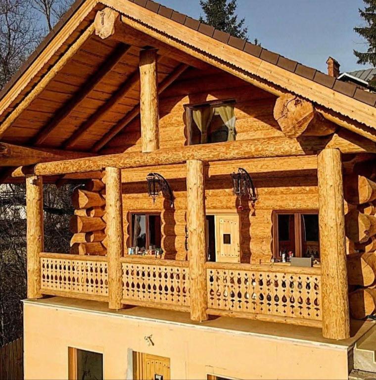 a log cabin with a wrap around porch at Rustic House in Predeal