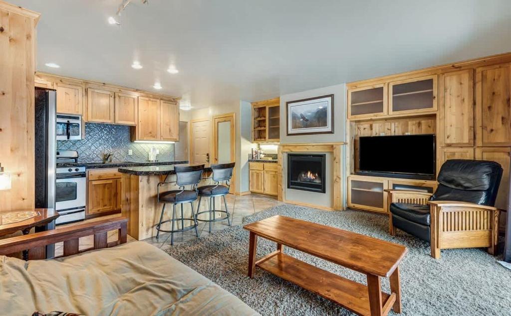 a living room with a couch a table and a kitchen at Rustic Pet-Friendly Second Floor Condo in Bend