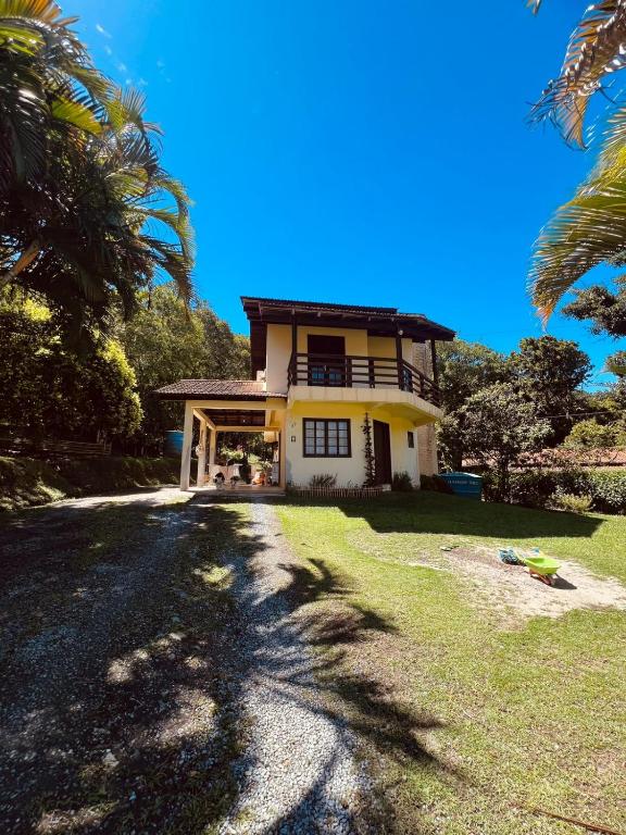 a house with a palm tree in front of it at Interior beach house in Bombinhas! in Bombinhas