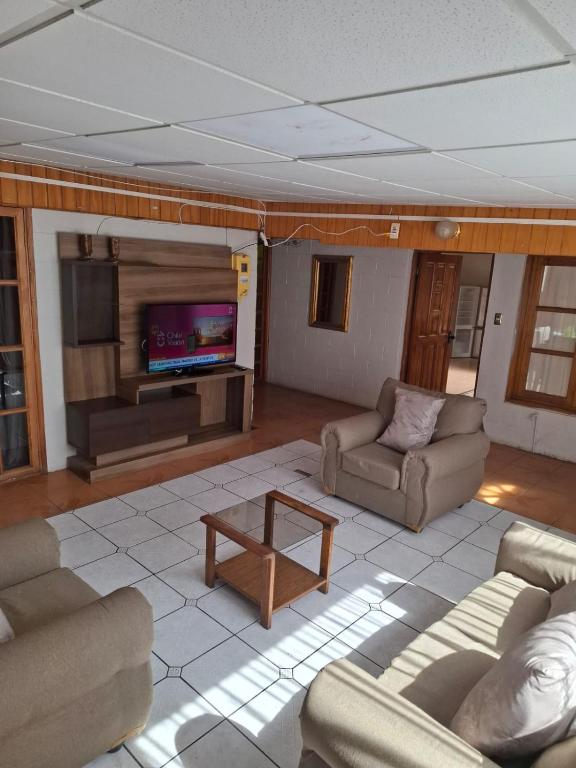 ein Wohnzimmer mit Sofas und einem Flachbildfernseher in der Unterkunft M&M Hospedaje in Calama