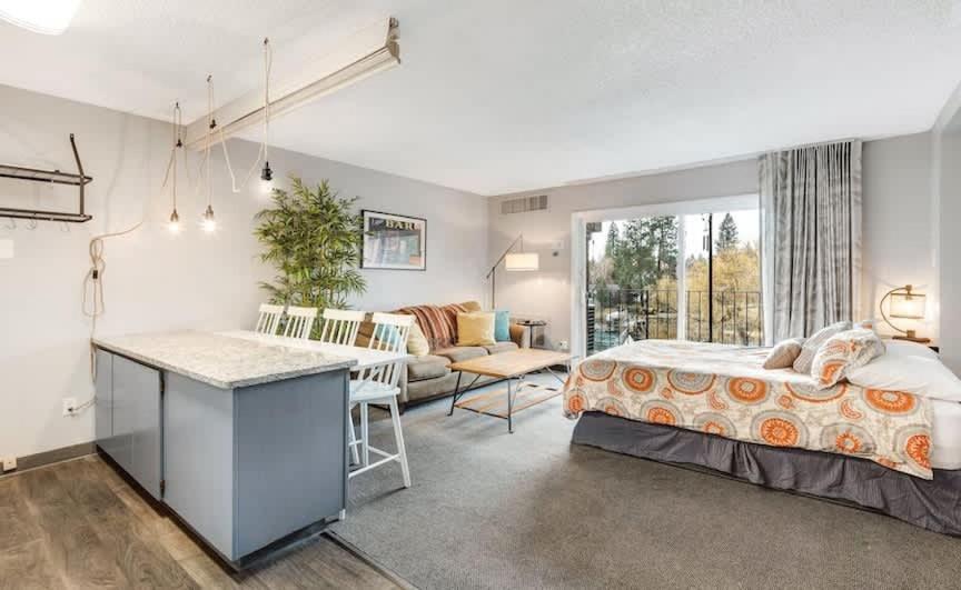 ein Schlafzimmer mit Bett und ein Wohnzimmer in der Unterkunft River View Condo- Edge of Downtown in Bend