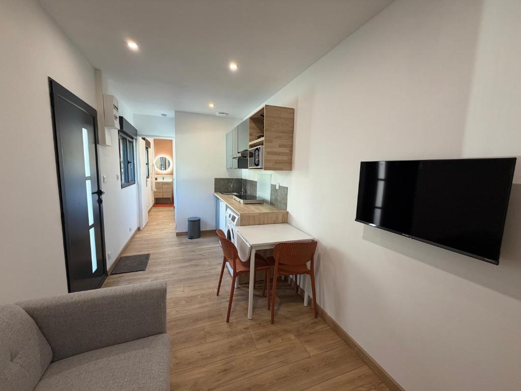 een keuken en woonkamer met een tafel en een televisie bij T2 Dream in Périgueux