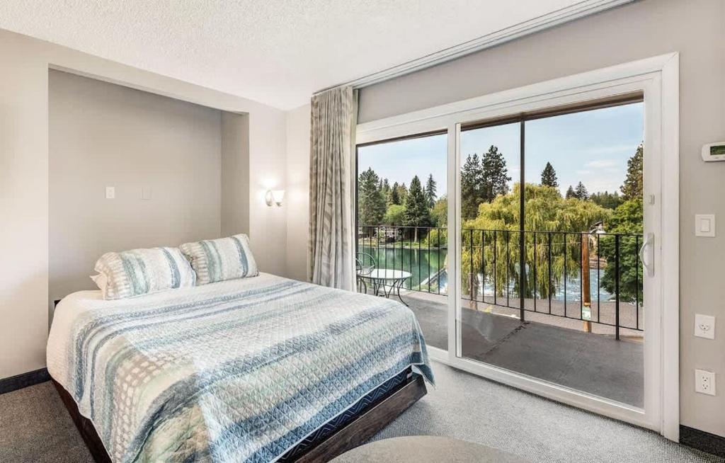 ein Schlafzimmer mit einem Bett und einem großen Fenster in der Unterkunft Riverfront Condo-No Better Place in Bend in Bend