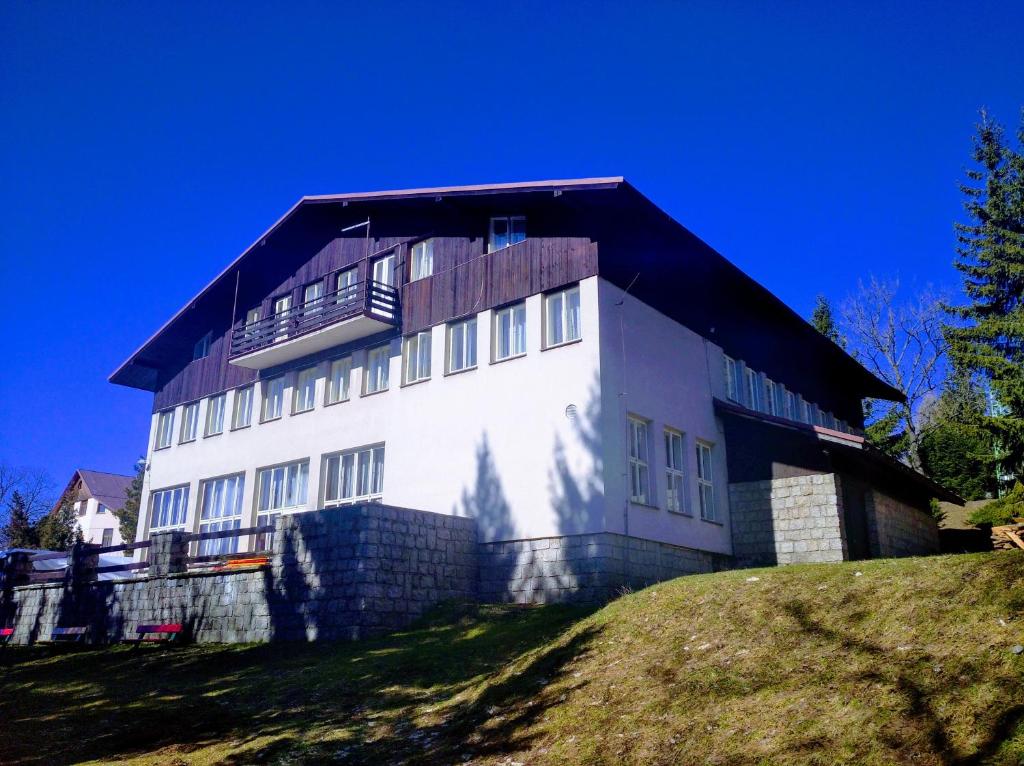 a large white building on top of a hill at Penzion Koniklec in Jestrabi V Krkonosich