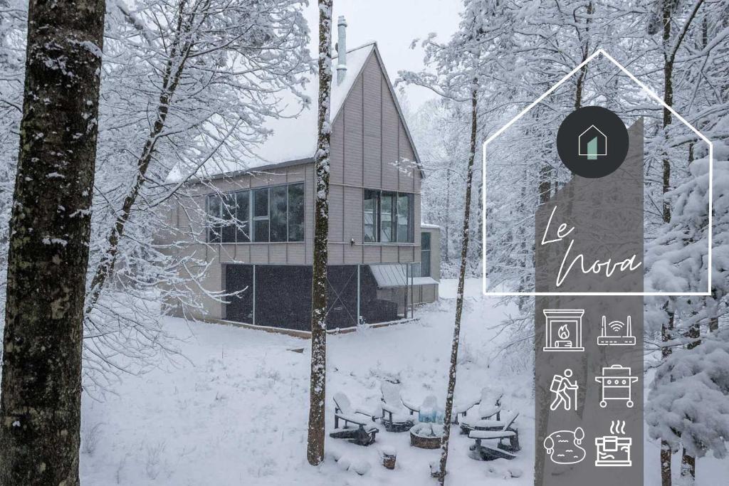 een huis in de sneeuw met een bord ervoor bij Chalet Nova - Well being and fullness in Grande Vallee
