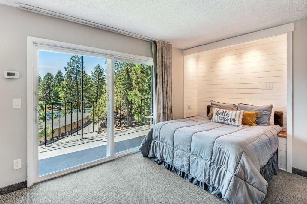 ein Schlafzimmer mit einem Bett und einem großen Fenster in der Unterkunft Riverfront Condo - Pet Friendly Near Downtown in Bend