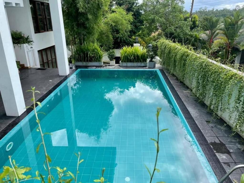 een zwembad in de achtertuin van een huis bij Peacock's Paradise Safari Hostel in Udawalawe
