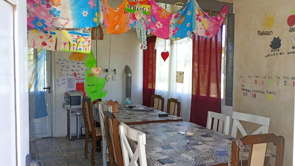 una sala da pranzo con tavolo, sedie e bandiere di Laila y León a General Juan Madariaga