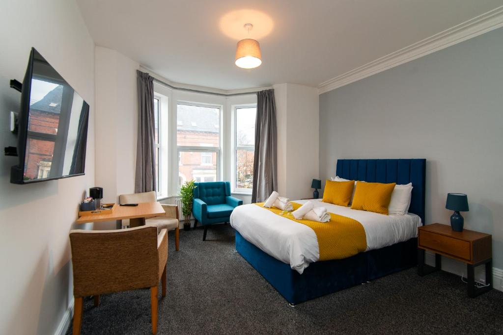 a bedroom with a bed and a desk and a chair at The Linden Leaf Rooms with free car parking in Nottingham