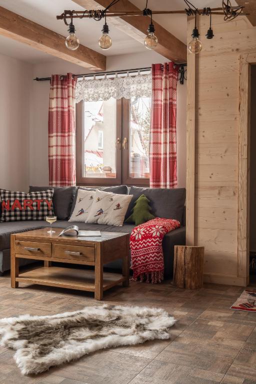 a living room with a couch and a coffee table at Tatra Prime in Bukowina Tatrzańska