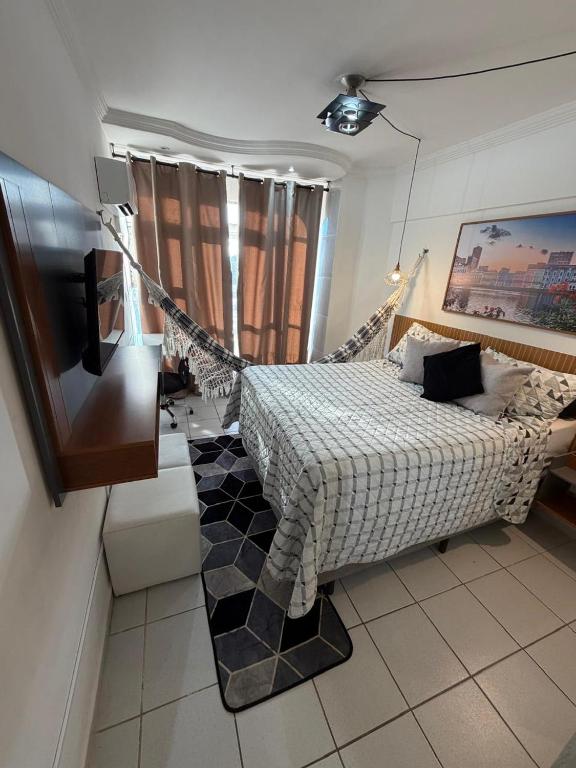 una camera da letto con un letto e una televisione di Apto Recife Aurora Mar e Rio a Recife