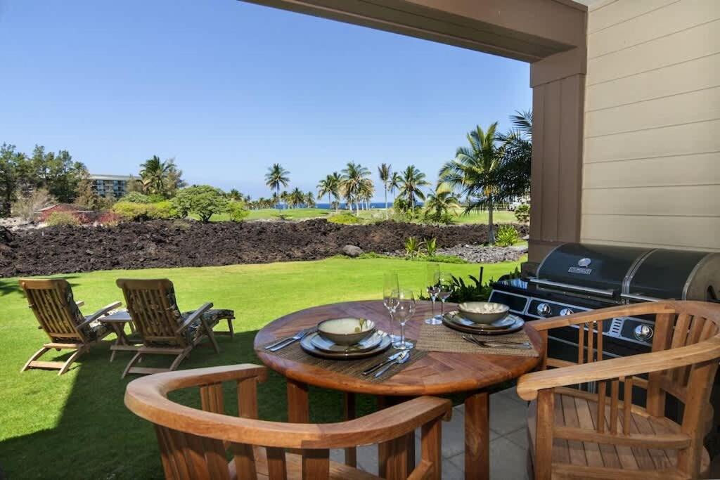 a patio with a table and chairs and a grill at Waikoloa condo with golf & ocean views in Waikoloa