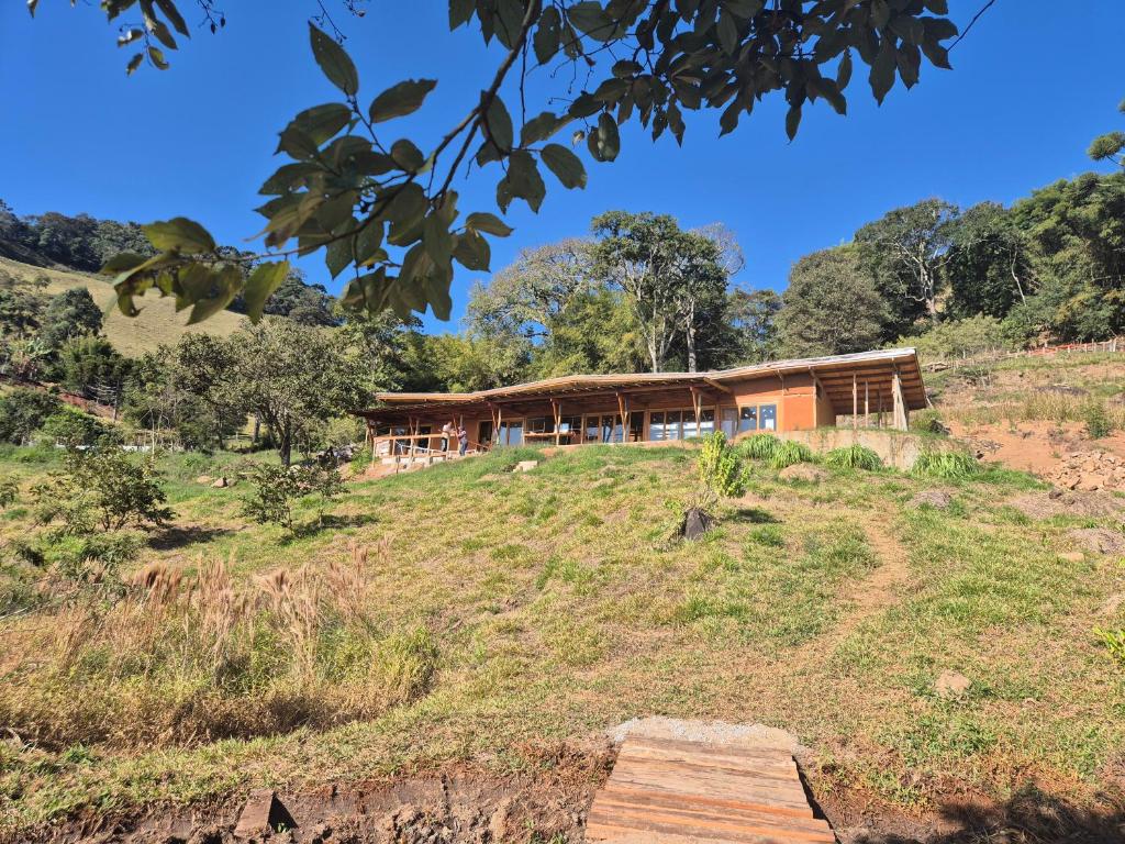a house on top of a grassy hill at Casa Solar in São Bento do Sapucaí