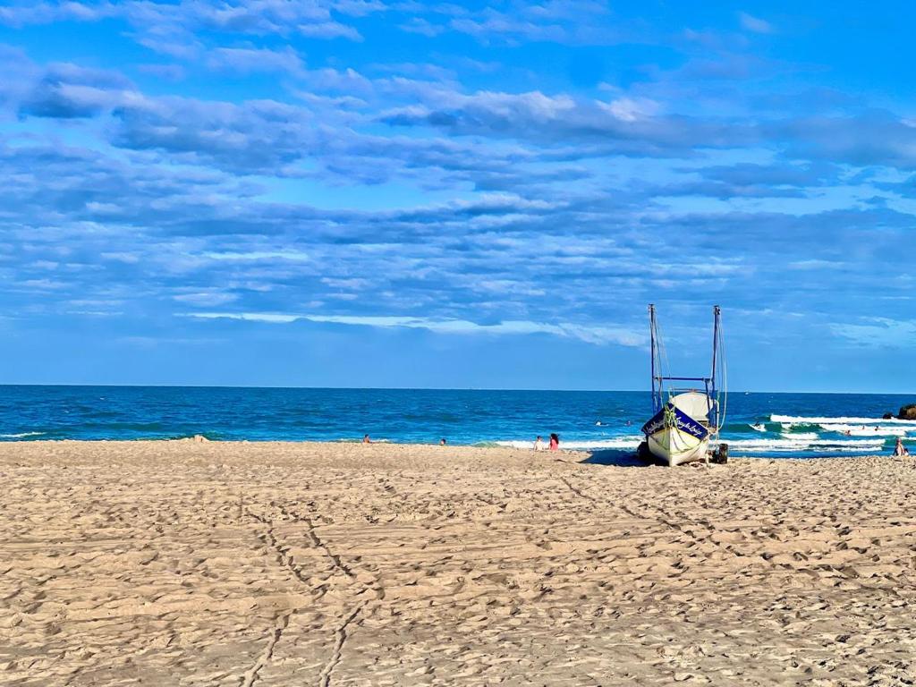 a boat sitting on a sandy beach next to the ocean at #PaRtiU PrAiA, 50 passos do Mar in Matinhos