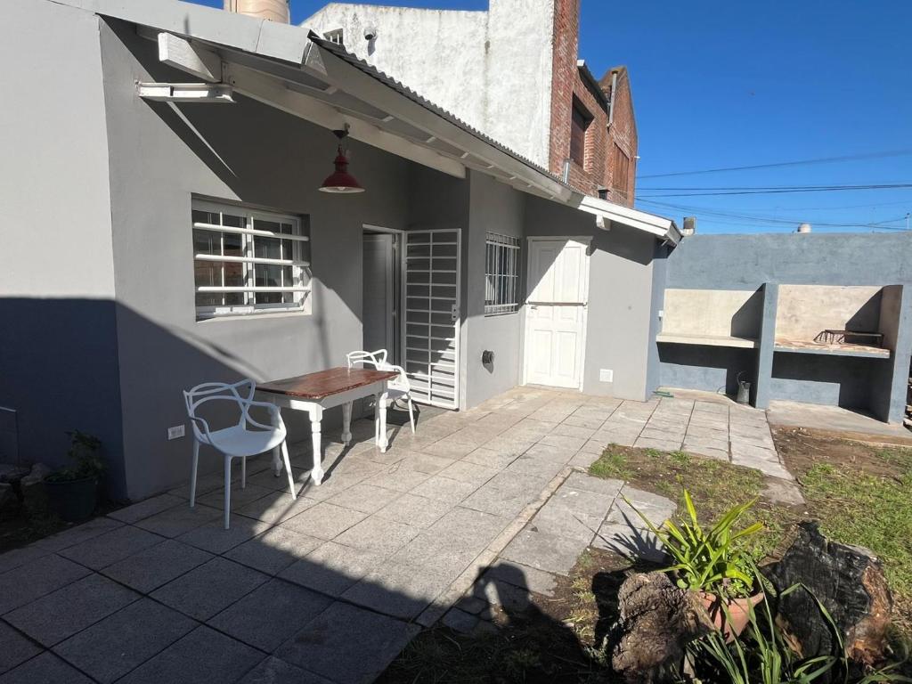 een terras met een tafel en stoelen voor een huis bij Mansilla playa in Mar del Plata