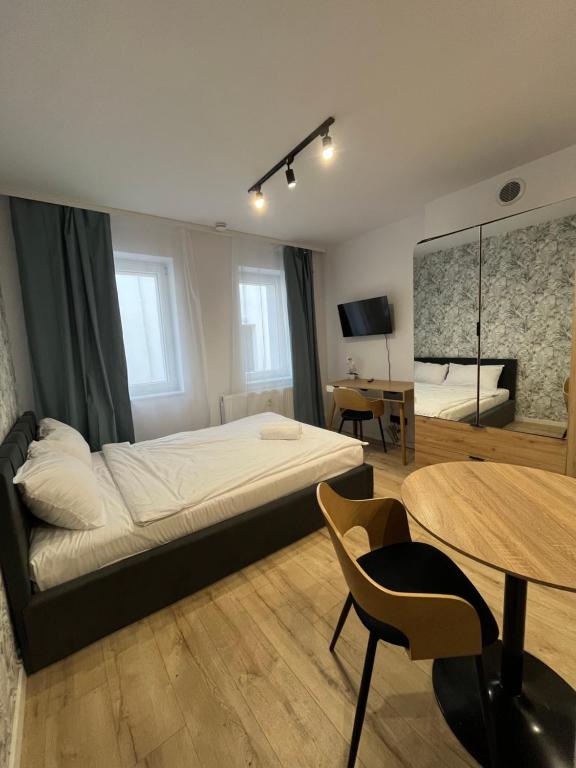 卡托维兹Flow Apartments - Świętego Pawła 10的一间卧室，里面有一张床、一张桌子和几把椅子。