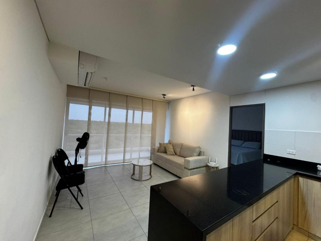 una cucina e un soggiorno con divano e TV di Harly's Castelo Apartment a Serena del Mar