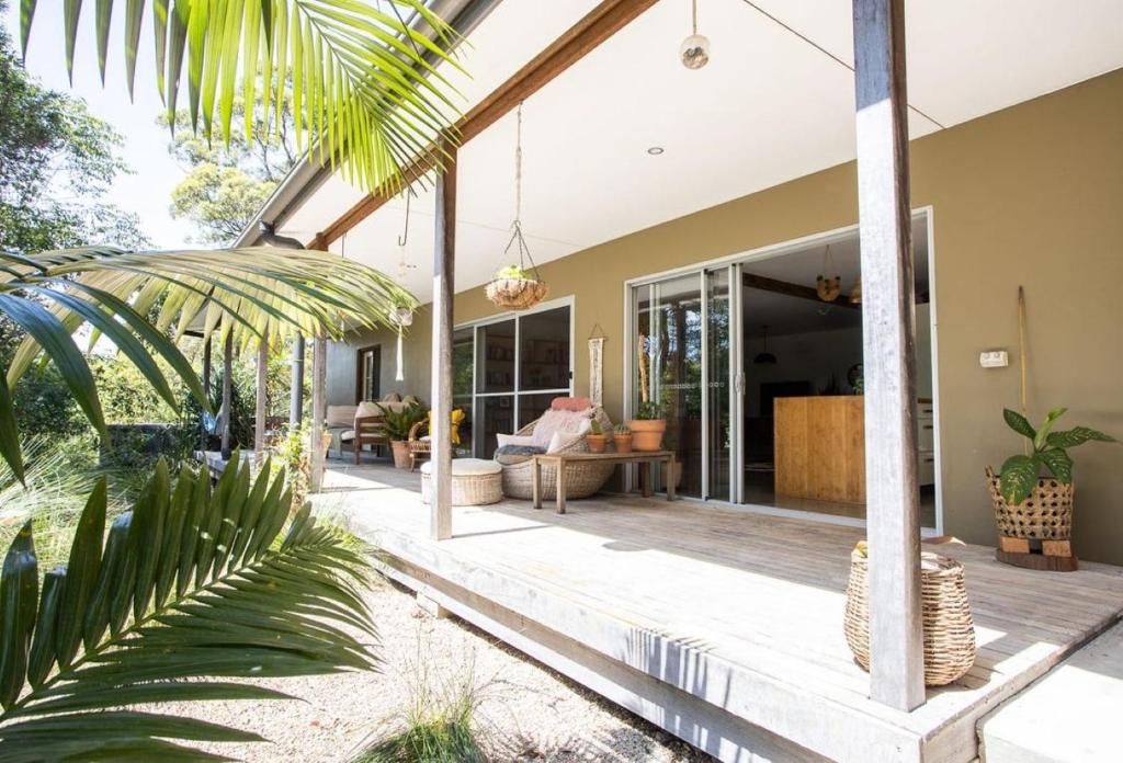 an open porch of a house with palm trees at Honeybird Hideaway in Crabbes Creek