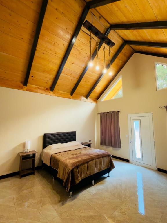 a bedroom with a large bed and wooden ceilings at Bungalows Bosque Selah in Nebaj