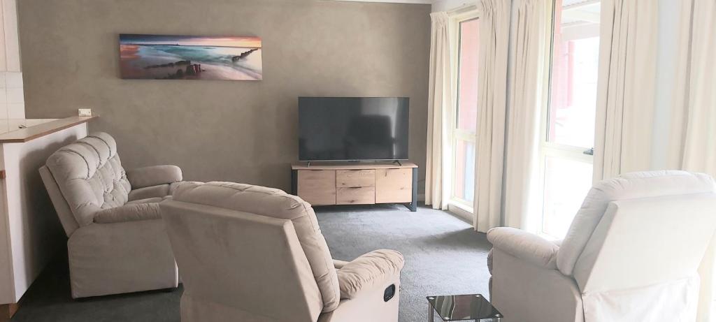 een woonkamer met twee stoelen en een televisie bij Margarets Lane in Warrnambool
