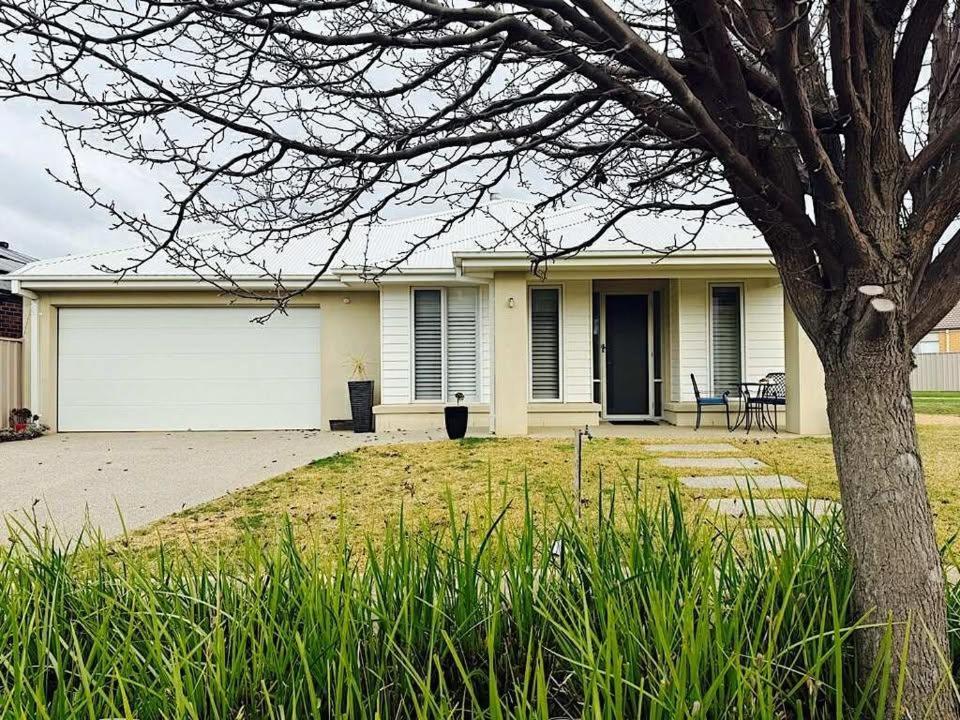 een wit huis met een boom ervoor bij Lakeside Nagambie 4guests in Nagambie