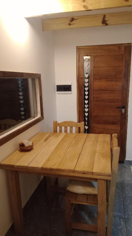 a wooden table with two chairs and a wooden door at Paraje Sur in Ushuaia