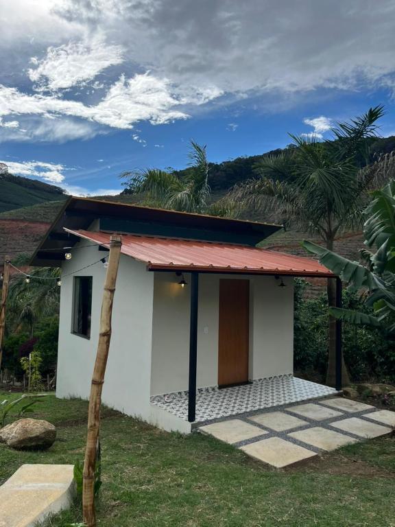 a small white house with a red roof at chalé cilla in Caparaó Velho
