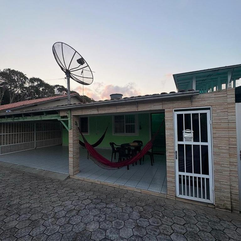 ein Haus mit einer Terrasse mit Hängematte in der Unterkunft Casa Ver-de-perto o Mar in Barra Velha