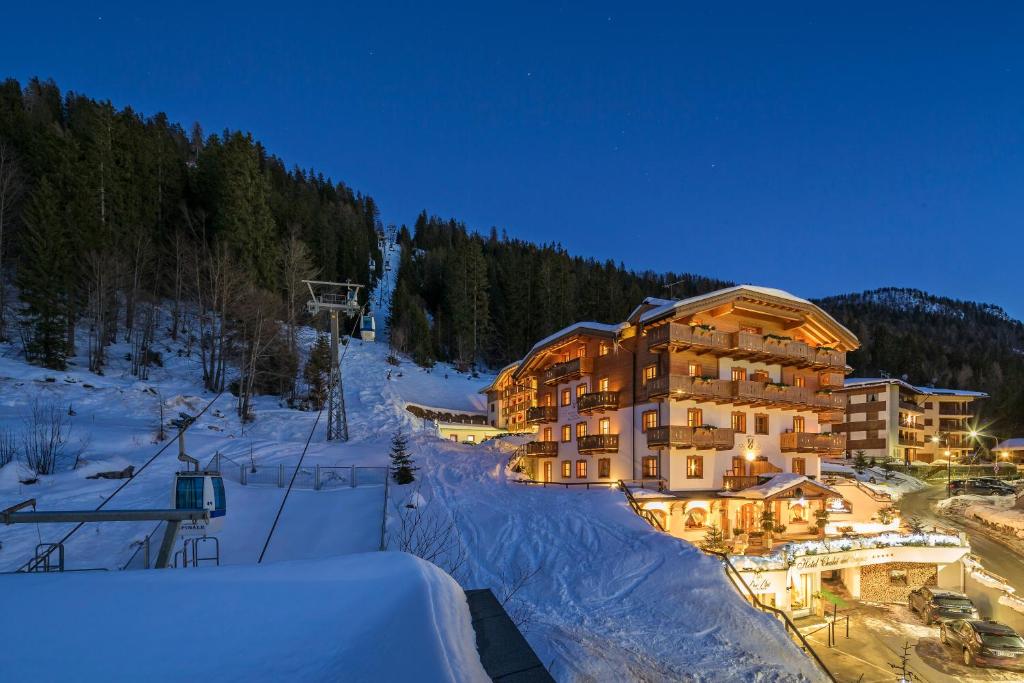 un gran edificio en la nieve por la noche en Hotel Chalet Del Sogno en Madonna di Campiglio