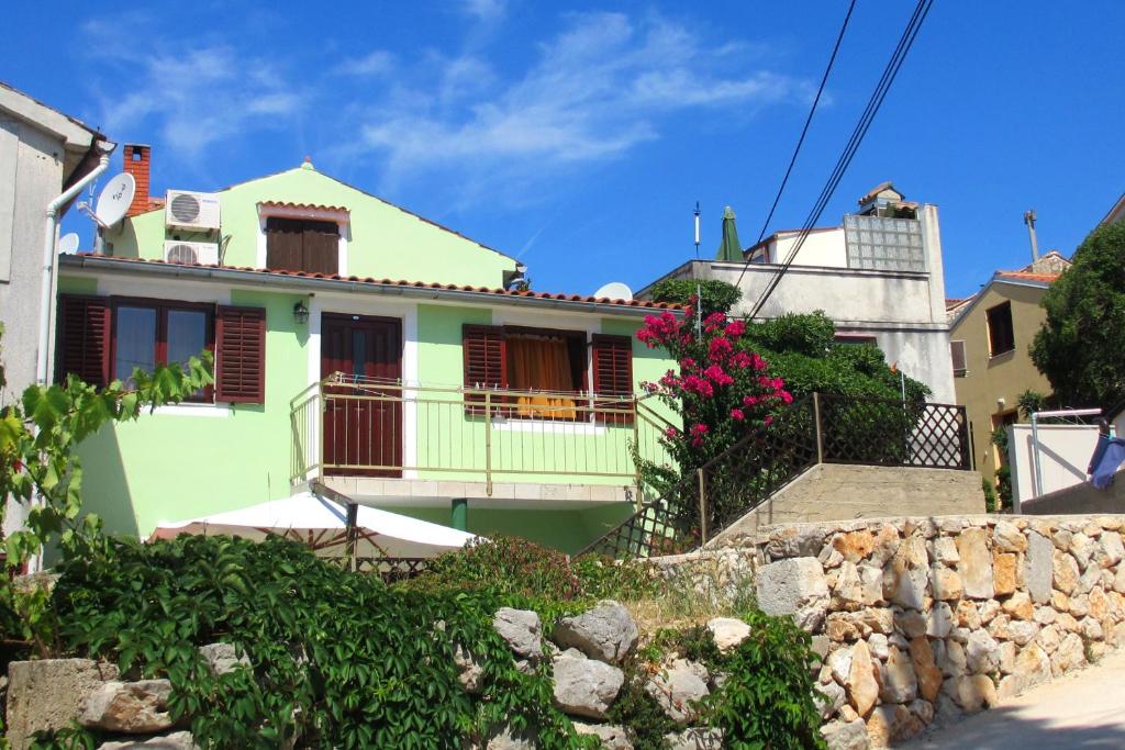 una casa verde con un balcone su una strada di Studio Cunski 7951a a Čunski