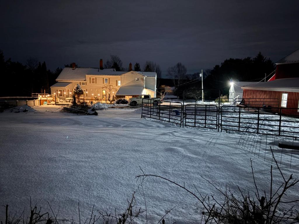 a barn with snow on the ground at night at My Valhalla Farm in Oakland