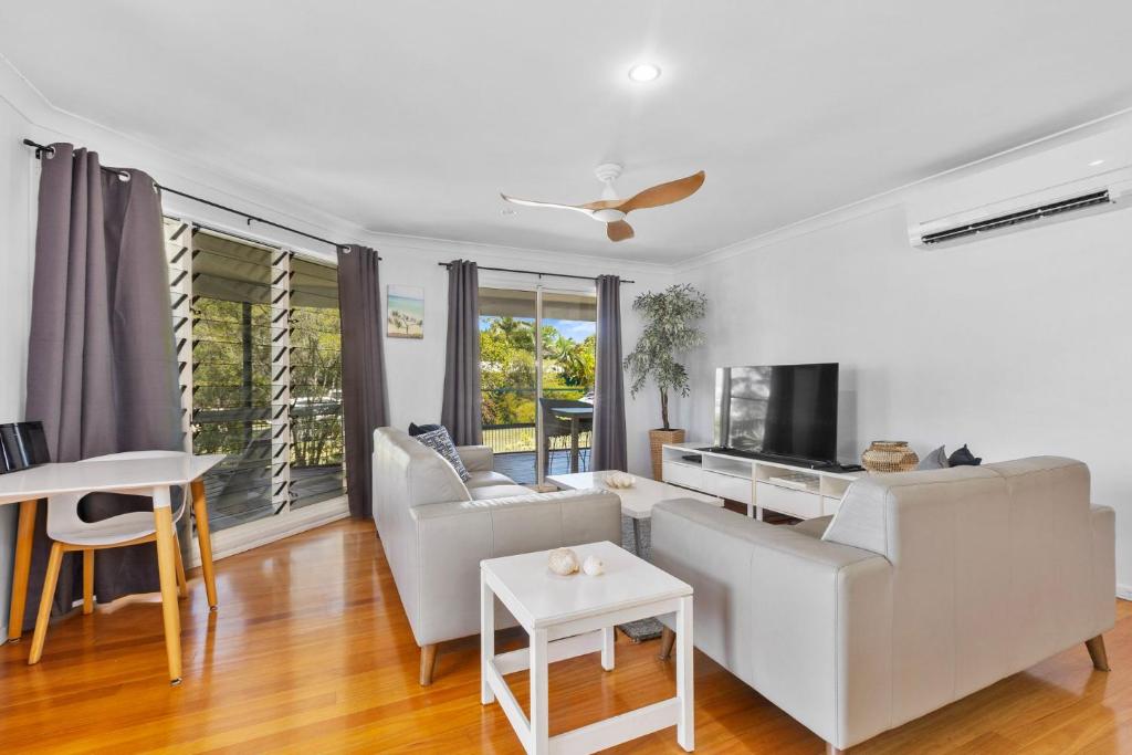 a living room with white furniture and a large window at Rainbow Tides - Rainbow Beach in Rainbow Beach