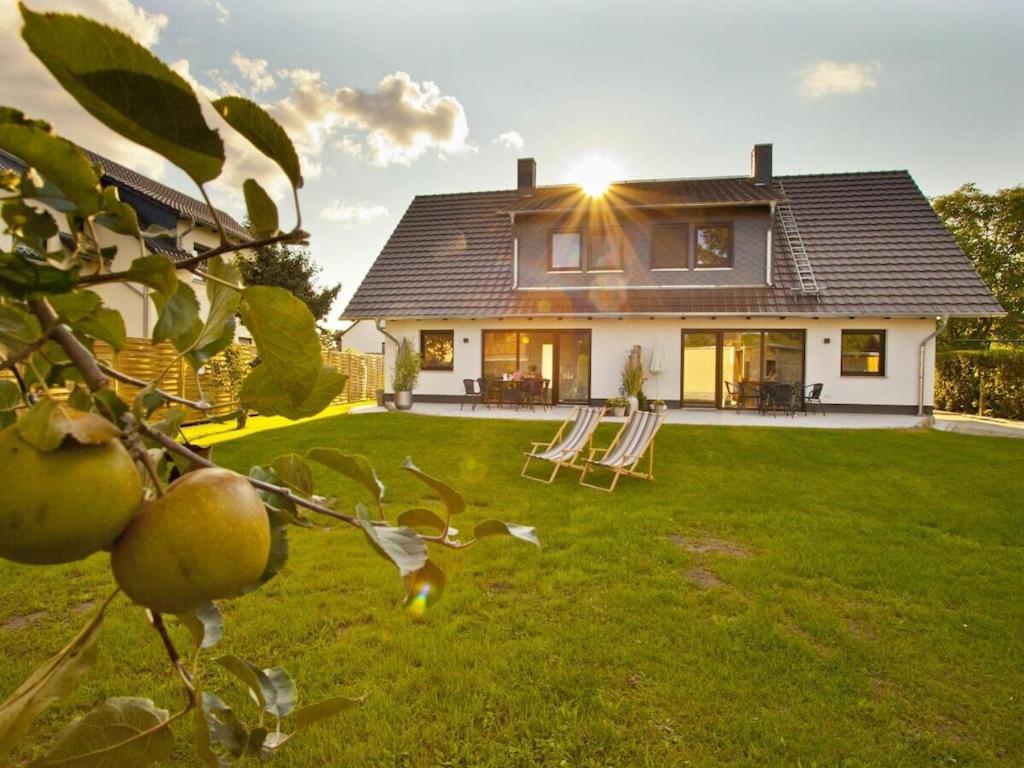 ein Haus mit einem Garten mit Stühlen und einem Apfelbaum in der Unterkunft Spreewald holiday home - Esox in Steinkirchen