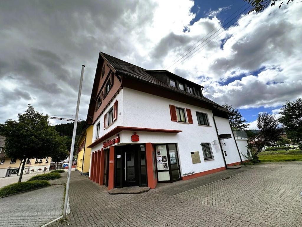 ein weißes Gebäude mit roten Türen auf einer Straße in der Unterkunft Dream holiday apartment Kinzigblick in Schenkenzell
