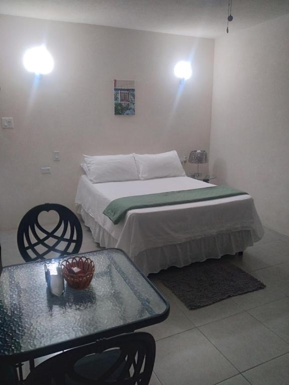 Schlafzimmer mit einem Bett, einem Tisch und Lampen in der Unterkunft C'VAR Community Vacation Apartment Rentals in Saint Michael