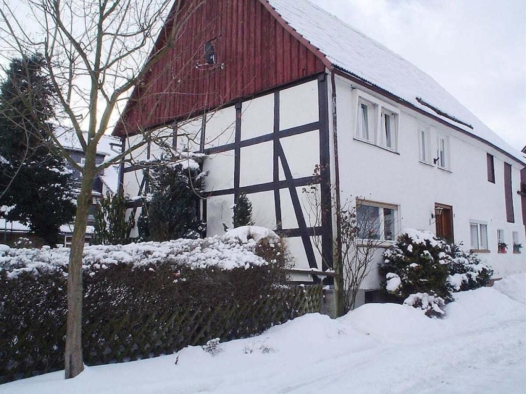 een wit huis met een rood dak in de sneeuw bij Wittmar in Medebach Sauerland in Medebach