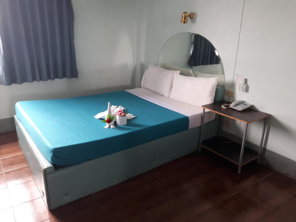 a bedroom with a bed with a mirror and a table at Anodard Hotel in Nakhon Sawan