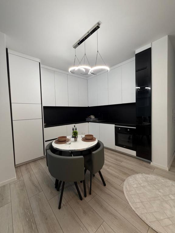 een keuken met een tafel en stoelen in een kamer bij Genial Apartments in Gjakove