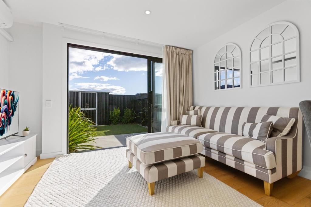ein Wohnzimmer mit Sofa und Glasschiebetür in der Unterkunft Flexible Bed Options, Private Back Yard, Car Park in Albert Town