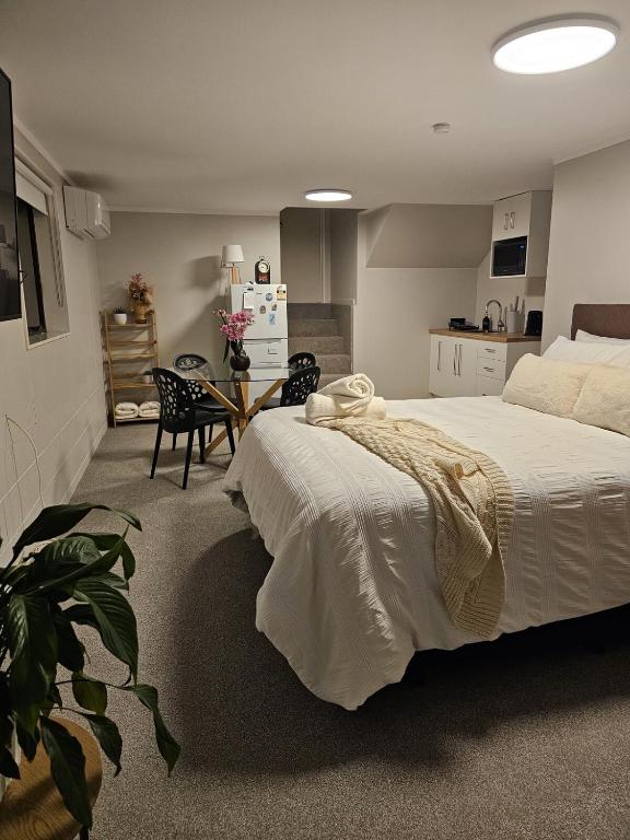 una camera con un grande letto bianco e una cucina di Guest suite Sleeps 4 a New Plymouth