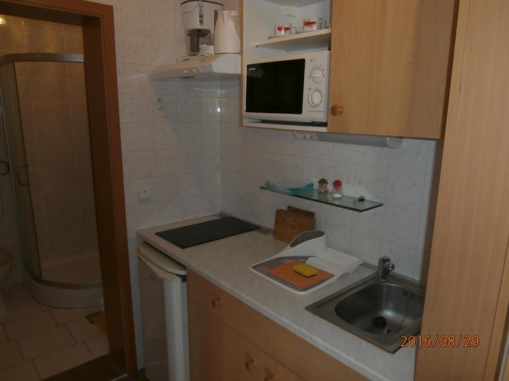 a small kitchen with a sink and a microwave at Apartments Meni in Drage