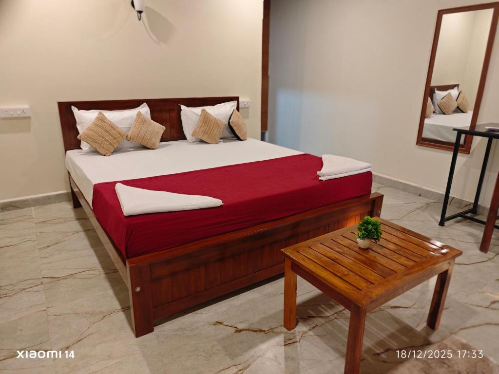 a bedroom with a large bed with a table at Colomb Beach Cottages in Patnem