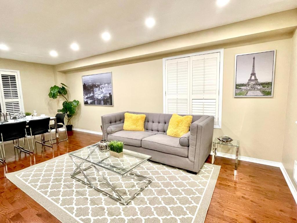 ein Wohnzimmer mit Sofa und Tisch in der Unterkunft Maison Laurier, Modern 5B4B Home Inc BSMT Free parking, Close to trails in Richmond Hill