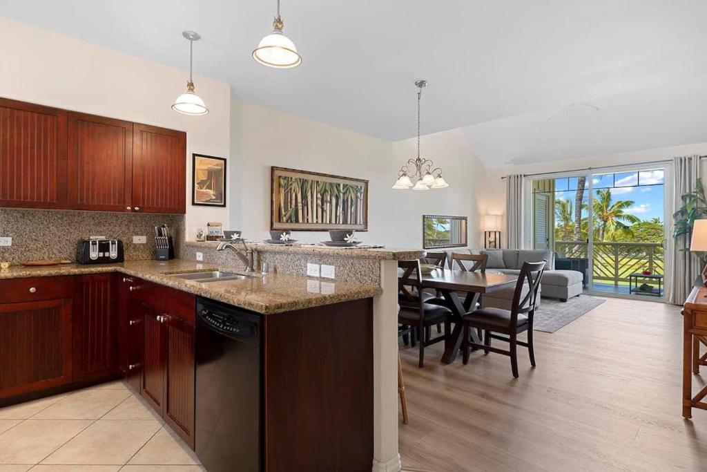 a kitchen and dining room with a dining table at Spacious 2BR condo with lanai & pool in Waikoloa