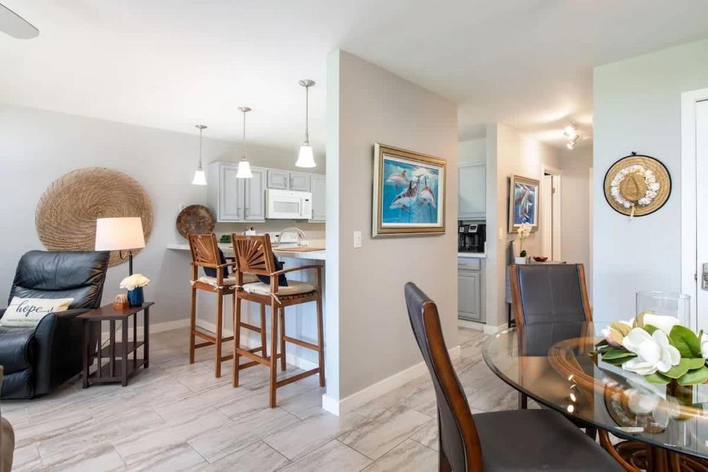 a living room with a table and a dining room at Tropical condo with pools lanai & BBQ in Waikoloa Village