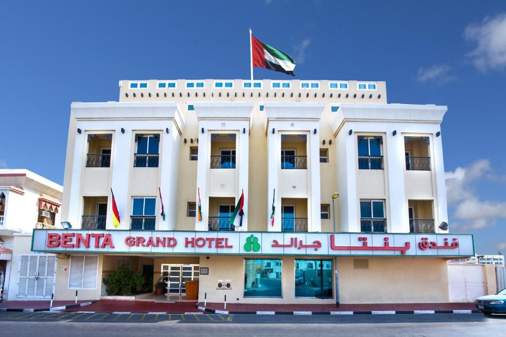 ein weißes Gebäude mit einer Flagge darüber in der Unterkunft Benta Grand Hotel LLC in Dubai