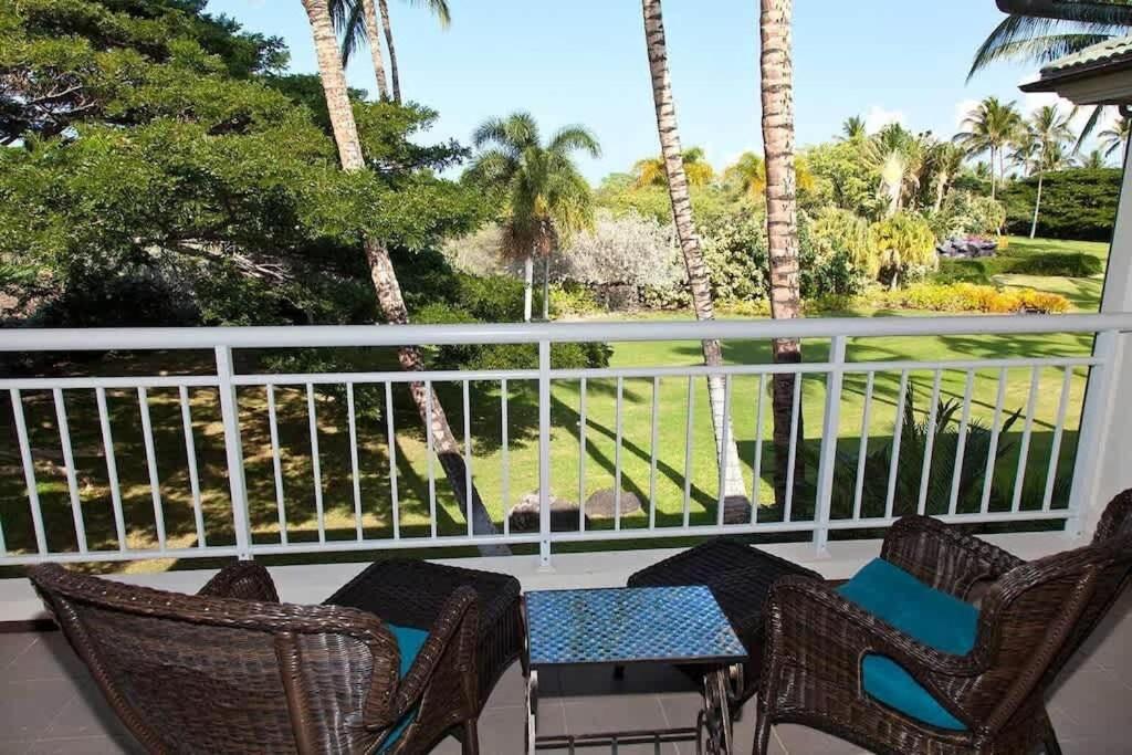 a balcony with chairs and a view of a golf course at Spacious retreat with pool & private lanai in Waikoloa