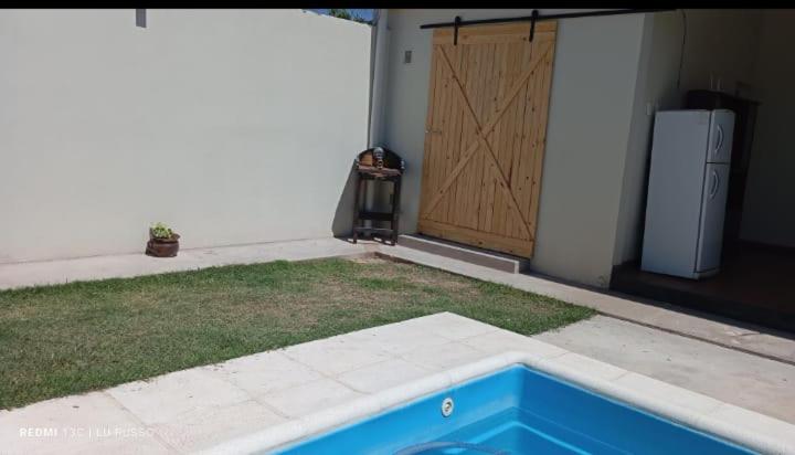 een achtertuin met een koelkast en een tuin met een deur bij Quincho Russo in Cerrillos