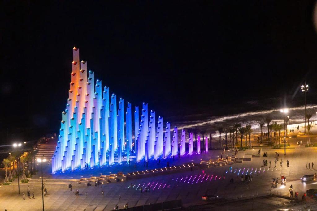 a building with blue and white lights on it at night at The V in Vung Tau